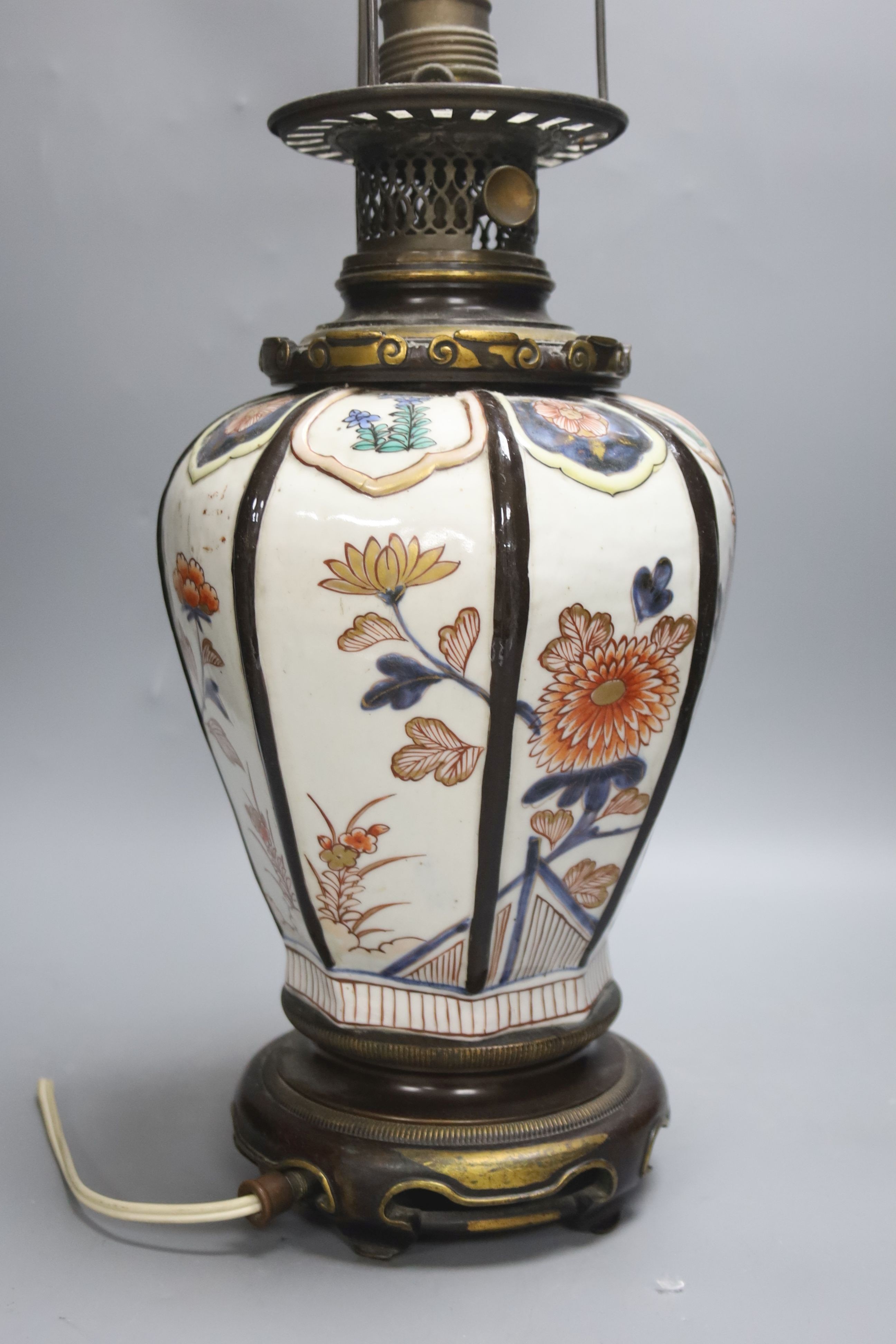 A Japanese Imari table lamp, of hexagonal form with gilt bronze fittings (formerly an oil lamp)